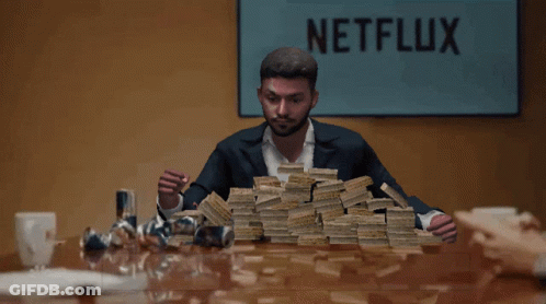 A Man Holding A Pile Of Money In Front Of A Netflix Sign GIF