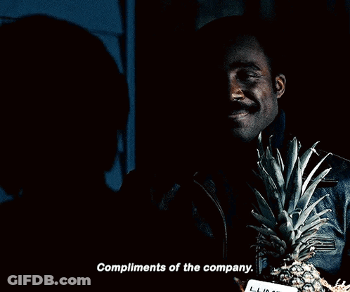 A Man Holding A Pineapple And A Card That Says Compliments Of The Company On It GIF