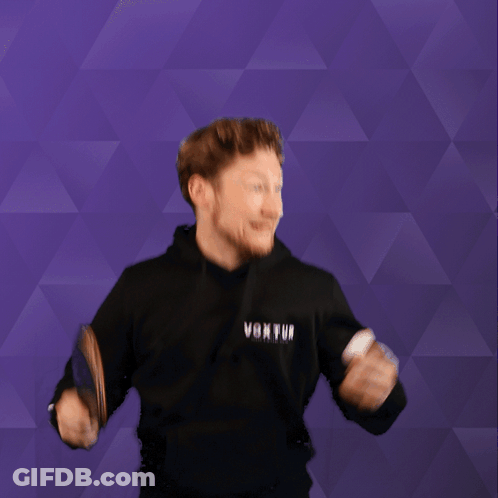 A Man Holding A Ping Pong Paddle And Wearing A Black Hoodie That Says Voxtui GIF