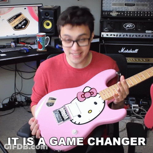 A Man Holding A Pink Hello Kitty Guitar With The Words It Is A Game Changer GIF