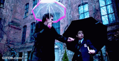 A Man Holding A Pink Umbrella And A Man Holding A Black Umbrella . GIF