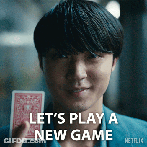 A Man Holding A Playing Card With The Words Let 'S Play A New Game Written Below Him GIF