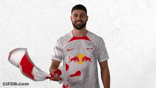 A Man Holding A Red And White Flag With A Bull On It GIF