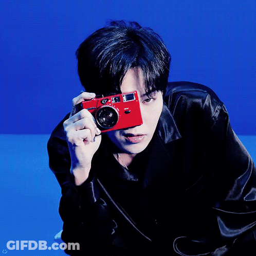 A Man Holding A Red Camera In Front Of His Face GIF
