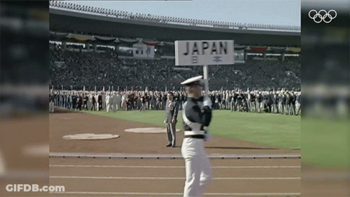 A Man Holding A Sign That Says Japan GIF
