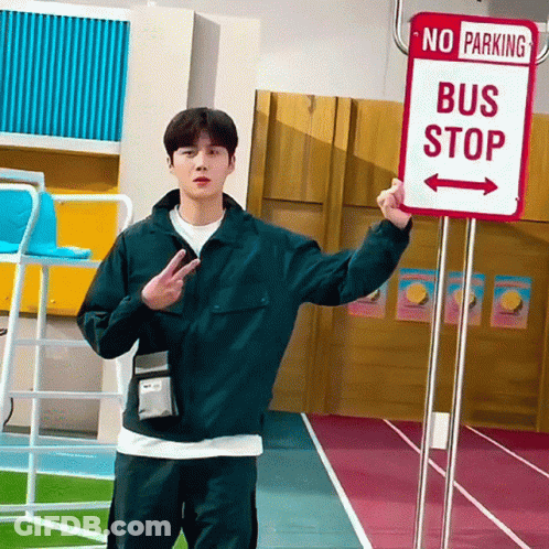 A Man Holding A Sign That Says No Parking Bus Stop GIF