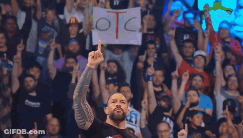 A Man Holding A Sign That Says Otc In Front Of A Crowd GIF