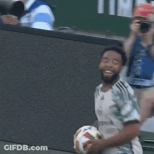 A Man Holding A Soccer Ball With A Shirt That Says Allmook On It GIF
