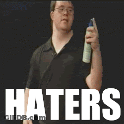 A Man Holding A Spray Bottle In Front Of A Sign That Says " Haters " GIF