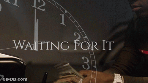 A Man Holding A Stack Of Money In Front Of A Clock That Says " Waiting For It " GIF