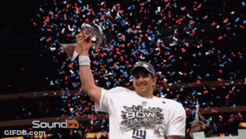 A Man Holding A Super Bowl Trophy With Confetti Falling Around Him GIF