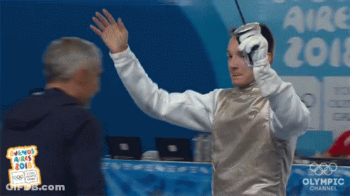 A Man Holding A Sword In Front Of An Olympic Channel Sign GIF