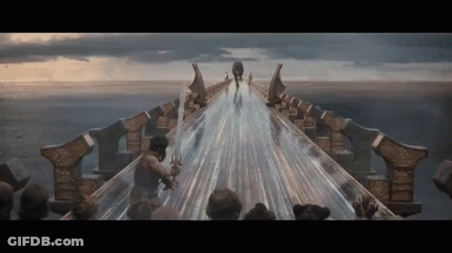 A Man Holding A Sword Is Walking Across A Bridge Over A Body Of Water GIF