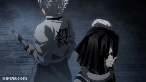 A Man Holding A Sword Stands Next To Another Man With A Snake On His Back GIF
