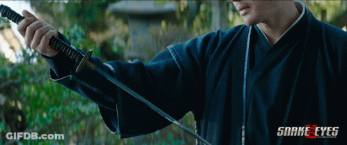 A Man Holding A Sword With Snake Eyes Written On The Bottom Right GIF