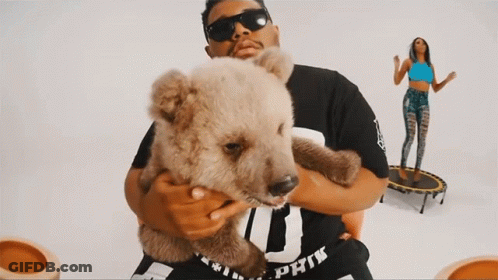 A Man Holding A Teddy Bear Wearing A Shirt That Says Pink GIF