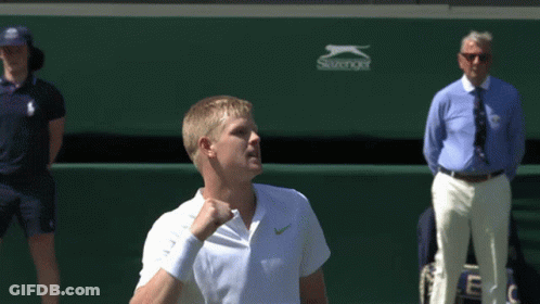A Man Holding A Tennis Racket In Front Of A Slazenger Logo GIF