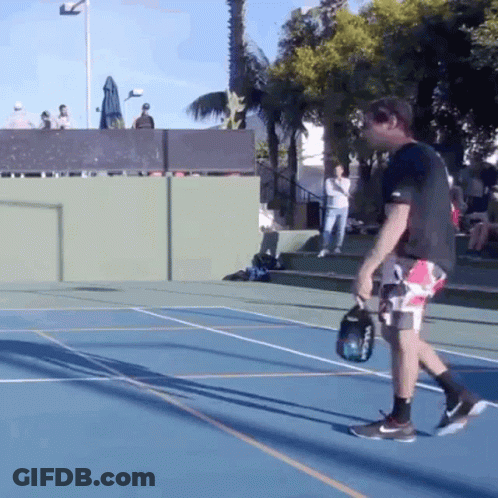 A Man Holding A Tennis Racket On A Court GIF