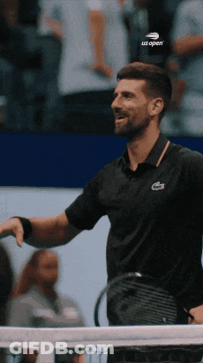 A Man Holding A Tennis Racquet And Wearing A Black Shirt That Says Us Open GIF