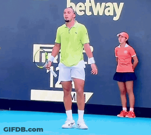 A Man Holding A Tennis Racquet In Front Of A Betting Wall GIF