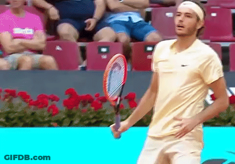 A Man Holding A Tennis Racquet In Front Of A Crowd GIF