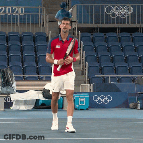 A Man Holding A Tennis Racquet In Front Of A Sign That Says 2020 On It GIF