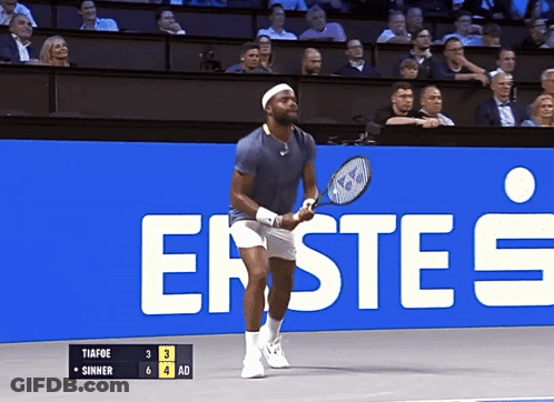 A Man Holding A Tennis Racquet In Front Of A Sign That Says Erste 'S GIF