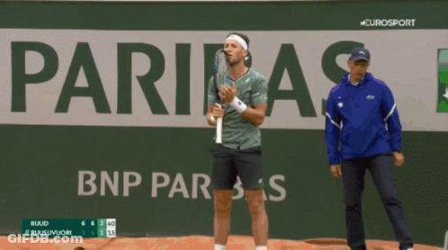A Man Holding A Tennis Racquet In Front Of A Sign That Says Eurosport GIF