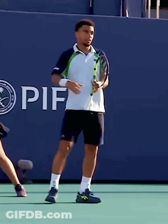 A Man Holding A Tennis Racquet In Front Of A Wall That Says If On It GIF