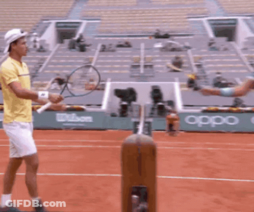 A Man Holding A Tennis Racquet On A Court With An Oppo Sign In The Background GIF