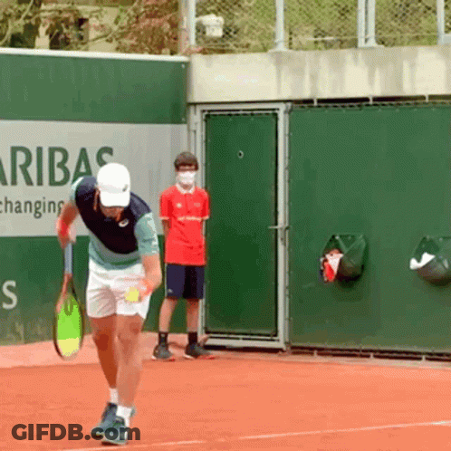 A Man Holding A Tennis Racquet On A Tennis Court In Front Of A Sign That Says Aribas GIF