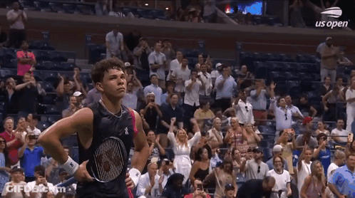 A Man Holding A Tennis Racquet Stands In Front Of A Crowd At Us Open GIF
