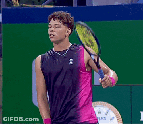 A Man Holding A Tennis Racquet While Wearing A Tank Top That Says Oc GIF