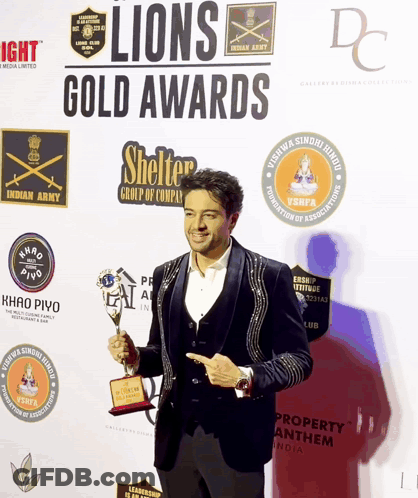 A Man Holding A Trophy At The Lions Gold Awards GIF
