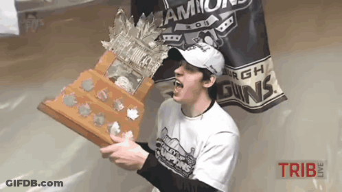 A Man Holding A Trophy In Front Of A Banner That Says ' Champs ' On It GIF
