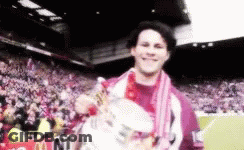 A Man Holding A Trophy In Front Of A Mcdonald 'S Banner GIF