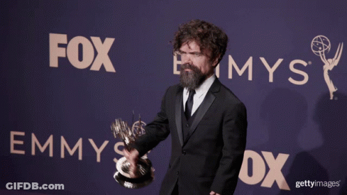 A Man Holding A Trophy In Front Of A Sign That Says Fox GIF