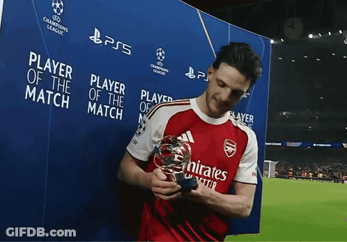 A Man Holding A Trophy In Front Of A Sign That Says " Player Of The Match " GIF