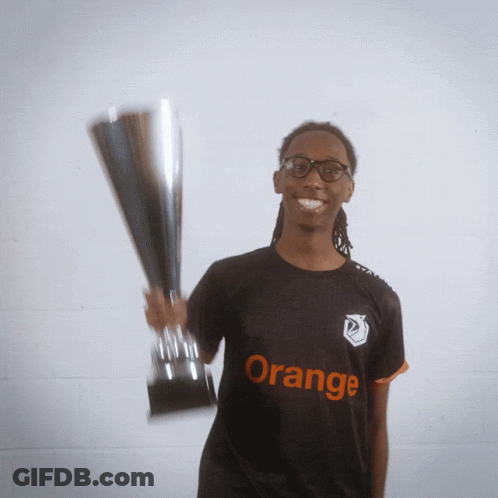 A Man Holding A Trophy Wearing An Orange Shirt GIF