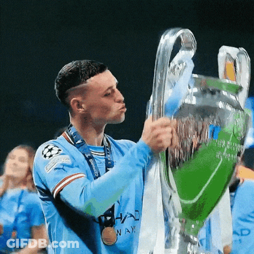 A Man Holding A Trophy With A Medal Around His Neck That Says ' Nay ' On It GIF