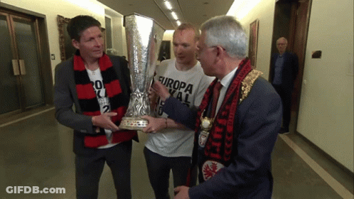 A Man Holding A Trophy With Europa On His Shirt GIF