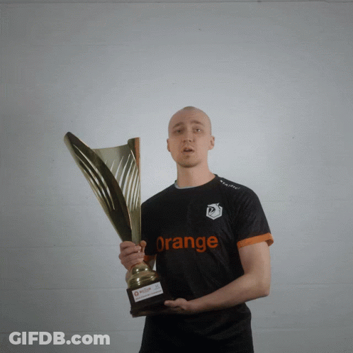 A Man Holding A Trophy With The Word Orange On His Shirt GIF