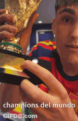 A Man Holding A Trophy With The Words Champions Del Mundo Below Him GIF
