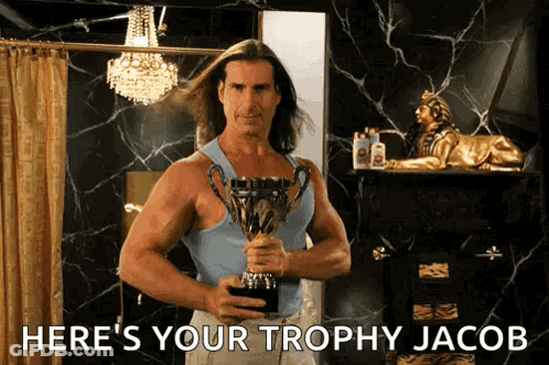 A Man Holding A Trophy With The Words Here 'S Your Trophy Jacob GIF