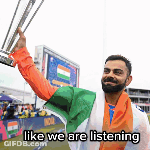 A Man Holding A Trophy With The Words Like We Are Listening Underneath Him GIF