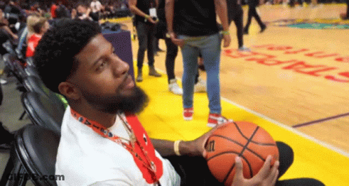 A Man Holding A Wilson Basketball On A Court GIF