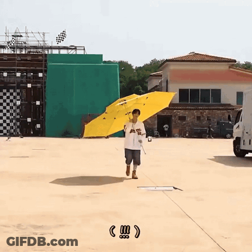 A Man Holding A Yellow Umbrella With The Word Angels On The Front GIF