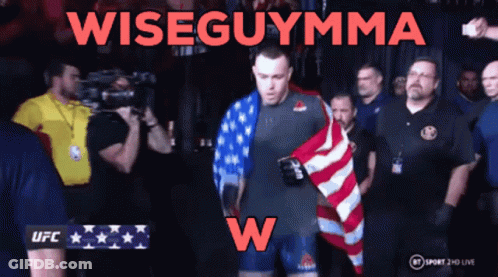 A Man Holding An American Flag With The Words Wiseguymma On The Bottom GIF