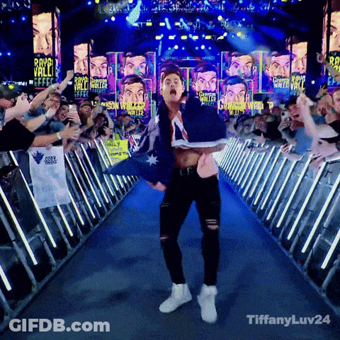 A Man Holding An Australian Flag Walks Down A Blue Aisle Surrounded By Fans GIF