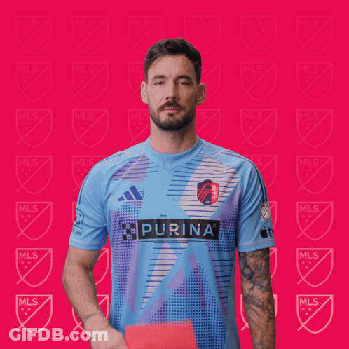 A Man Holding Up A Red Card That Says Purina GIF